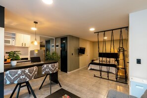 A modern apartment with a kitchen, dining area, and a bedroom with a swing bed. - Tranvia 40 (Medellín)