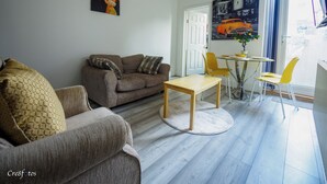 Un salon comprenant un canapé, une table basse et un coin repas avec des chaises et une table.
