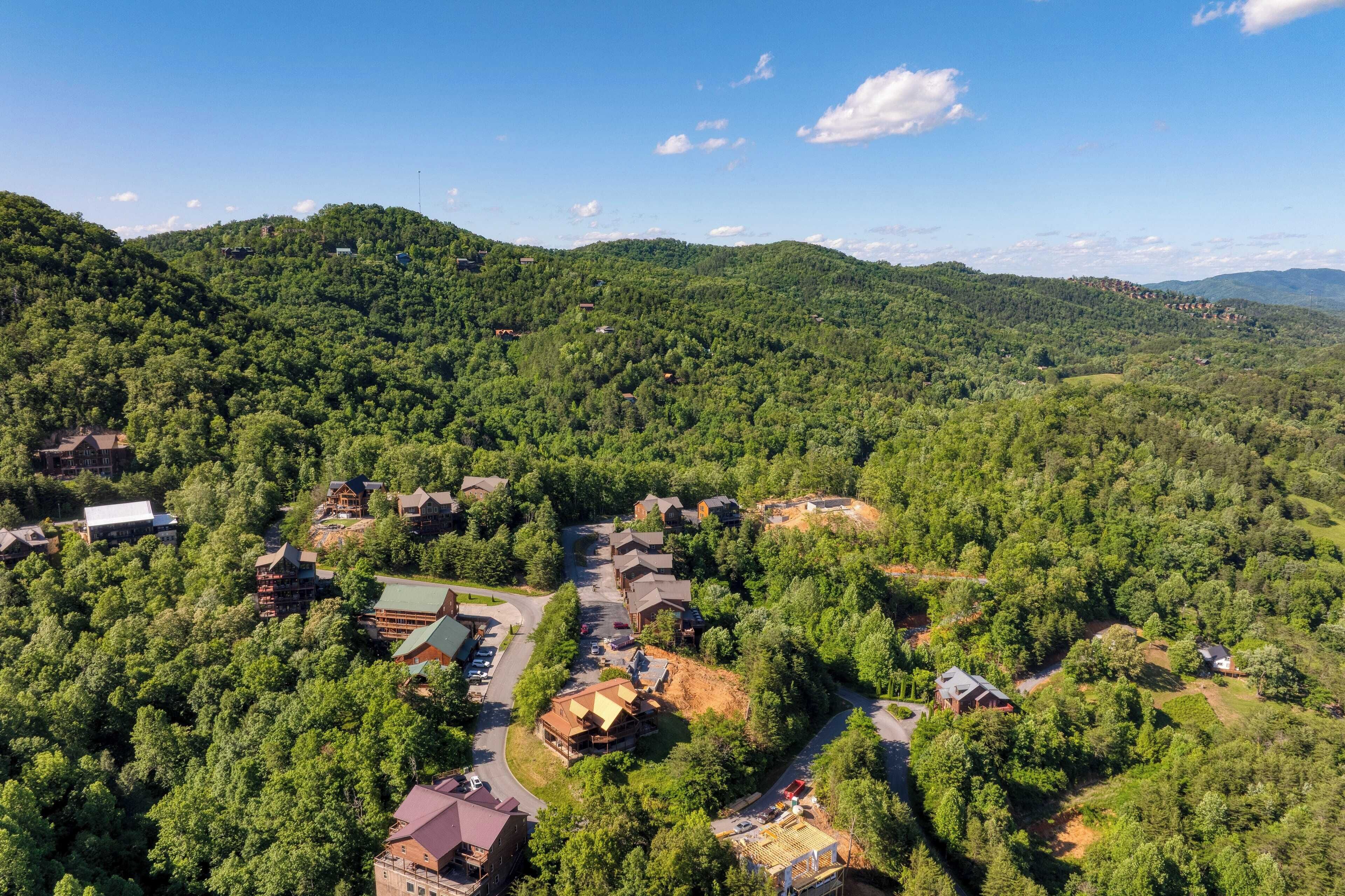 Ein Feriengebiet mit mehreren Gebäuden, umgeben von dichtem Wald, mit einer Hauptstraße und verschiedenen Bauten.