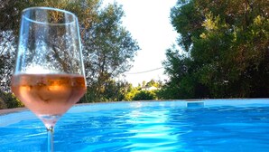 Una piscina al aire libre, sombrillas, sillones reclinables de piscina