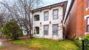 A two-story brick building with a white facade, multiple windows, and a visible front door. - OSU - Heart of Short North -STEPS from High ST-OSU (Columbus)