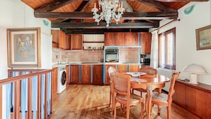 Una cocina rústica con armarios de madera, una mesa de comedor y un candelabro.