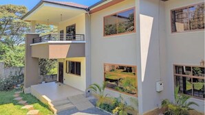 A modern two-story house with a balcony, large windows, and a well-maintained garden. - Luxury 9 Rooms Fullhouse in Karen Nairobi (Nairobi)