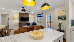 A modern kitchen with a marble countertop, pendant lighting, and a ceiling fan. - Stylish 1-bedroom condo Downtown Atlanta (Atlanta)