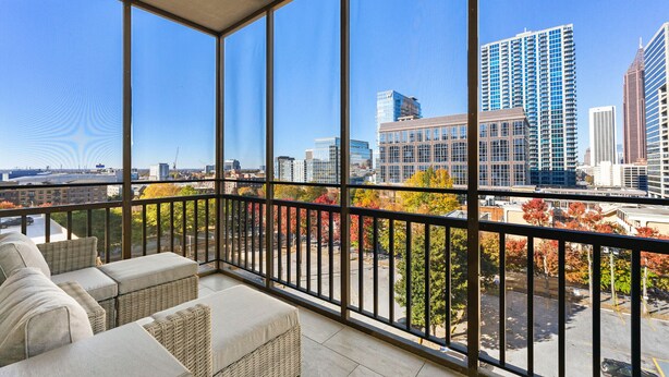 A balcony with wicker furniture and a city view. - Stylish 1-bedroom condo Downtown Atlanta (Atlanta)
