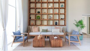A living room with a wooden bookshelf, two sofas, and two wooden coffee tables. - Entire condo in Puerto Vallarta, Mexico (Puerto Vallarta)