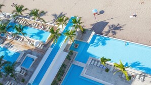 An aerial view of a resort with a swimming pool, beach, and palm trees. - Entire condo in Puerto Vallarta, Mexico (Puerto Vallarta)