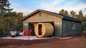 A rustic building with a large wooden barrel entrance, outdoor seating, and a red fence. - Gateway Getaway in wonderful Williams with fire pit, sauna, game room and views! (Williams)