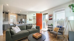 A modern living room with a green sofa, a wooden coffee table, and a chair. - Gateway Getaway in wonderful Williams with fire pit, sauna, game room and views! (Williams)
