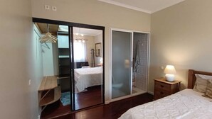 A bedroom with a bed, bedside table, and a wardrobe with a mirror. - Ben House - House with 3 bedrooms (Unknown)