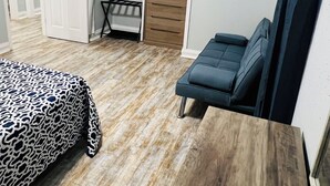 Une chambre à coucher comprenant un lit, une commode, un banc et une armoire.