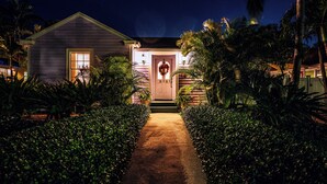 A house with a front porch, a door with a wreath, and a pathway leading to the entrance.