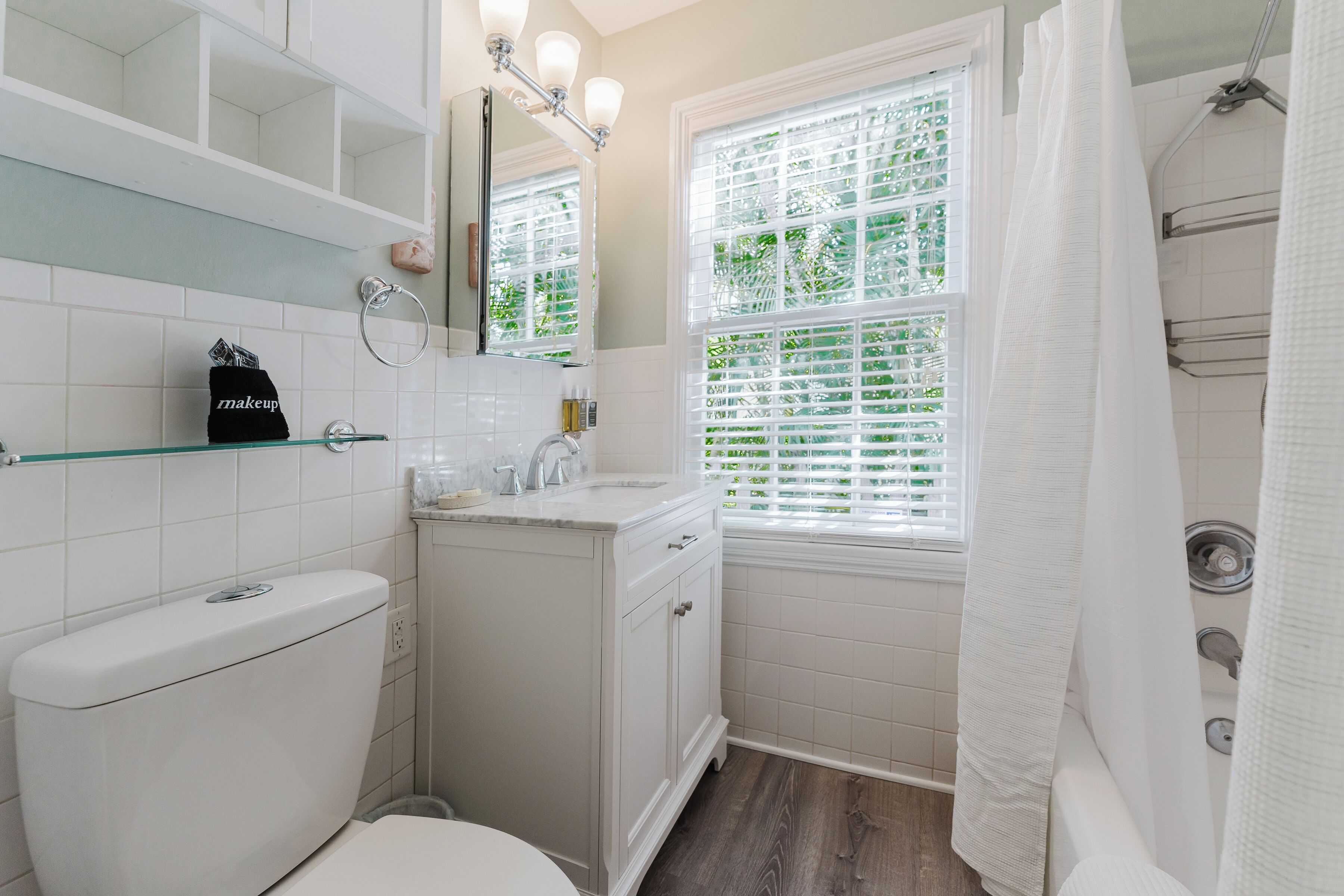 A bathroom with a toilet, sink, and shower area.