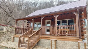 A wooden cabin with a porch, a staircase, and a stone wall foundation. - Tranquil Amish-built cabin near Wildcat State Park (Ontario)