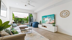 Una sala de estar moderna con un sofá, una mesa de centro y un cuadro grande en la pared.