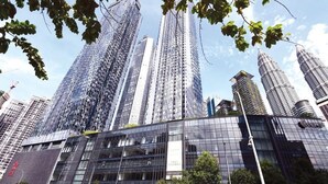 Ein modernes Hochhaus mit Glasfassade, umgeben von weiteren hohen Gebäuden.