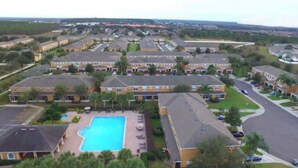A residential area with multiple two-story houses, a central swimming pool, and a well-maintained lawn. - Charming 2-bedroom townhome with WiFi, AC in brilliant Davenport (Davenport)