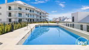 A modern apartment building with a swimming pool, balconies, and a clear blue sky. - Julicasa | Garden - pool - terrace (Fuengirola)