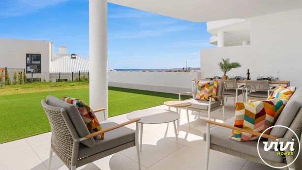 A modern outdoor patio with seating and a view of the sea. - Julicasa | Garden - pool - terrace (Fuengirola)