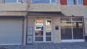 A multi-story building with a ground-level commercial space and upper residential units. - A- Centrally located apartment 9 de Julio I (San Carlos de Bariloche)
