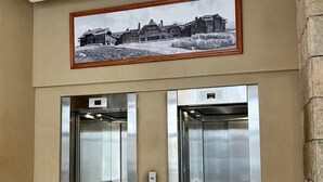 A pair of elevators in a lobby with a framed picture above them. - Exclusive downtown apartment (San Carlos de Bariloche)