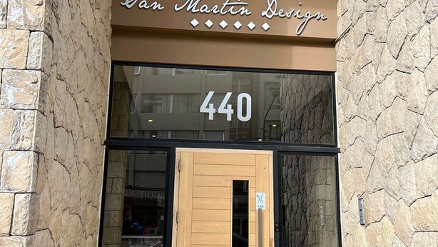 A storefront with a stone facade and a sign reading "San Martin Design 440". - Exclusive downtown apartment (San Carlos de Bariloche)