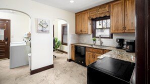 A kitchen with wooden cabinets, a dishwasher, a coffee maker, and a sink.