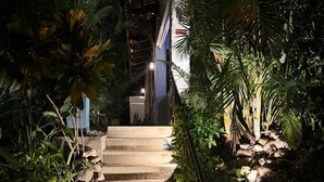 A stone staircase surrounded by lush greenery, leading to a building with a blue facade. - Casa de Palmas -Modern Villa in 4 Star Beach Resort Short Walk to Playa Hermosa! (Playa Hermosa)