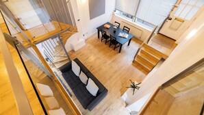 Een modern interieur met een eethoek, trap en een bank.