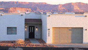 A modern house with a garage, a front door, and a number '205' on the wall.