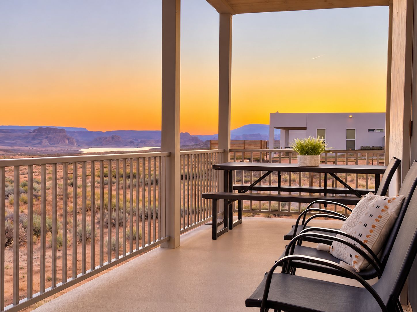 A balcony with a view of a desert landscape and a building in the background.