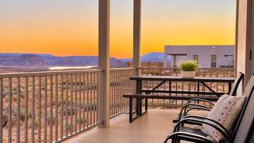 A balcony with a view of a desert landscape and a building in the background.