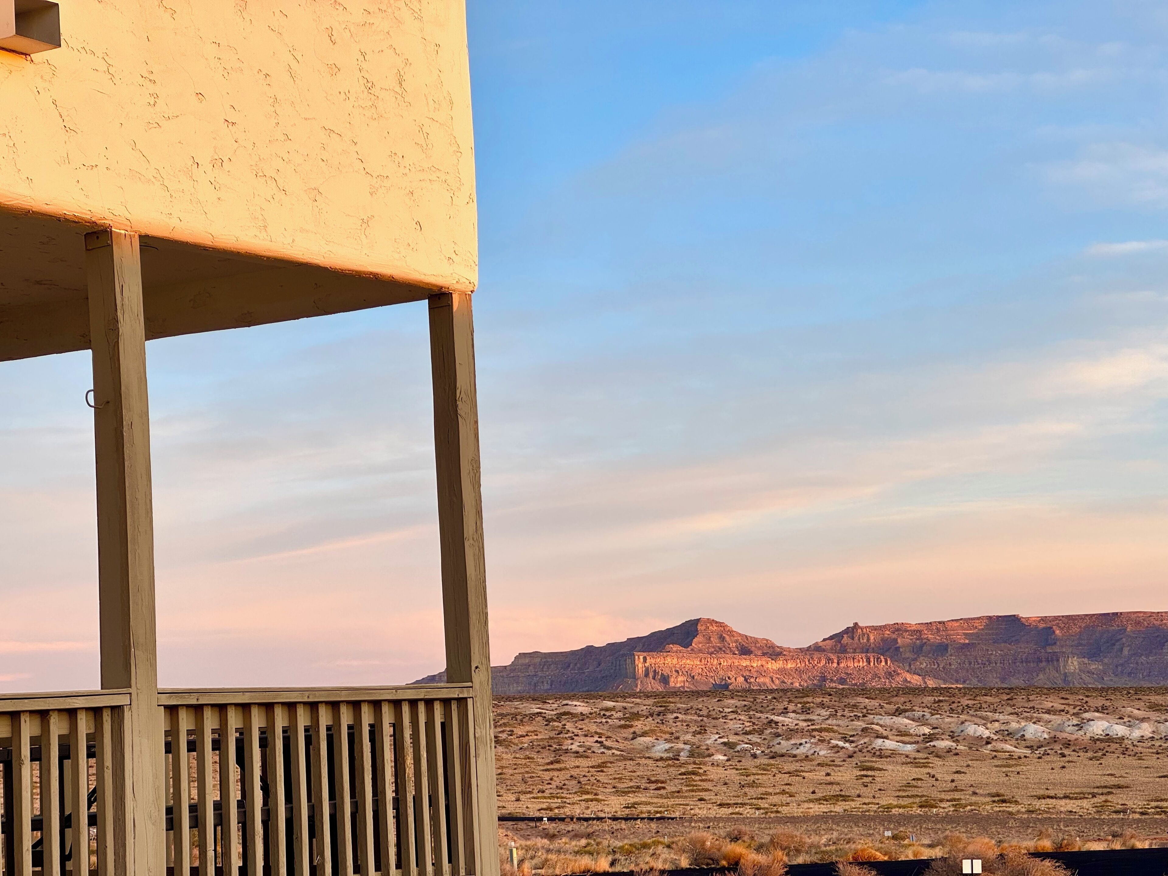Estructura de madera con vista a un paisaje desértico y montañas al fondo.