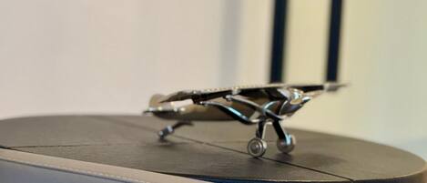 Una pequeña mesa redonda con un modelo de avión metálico encima.