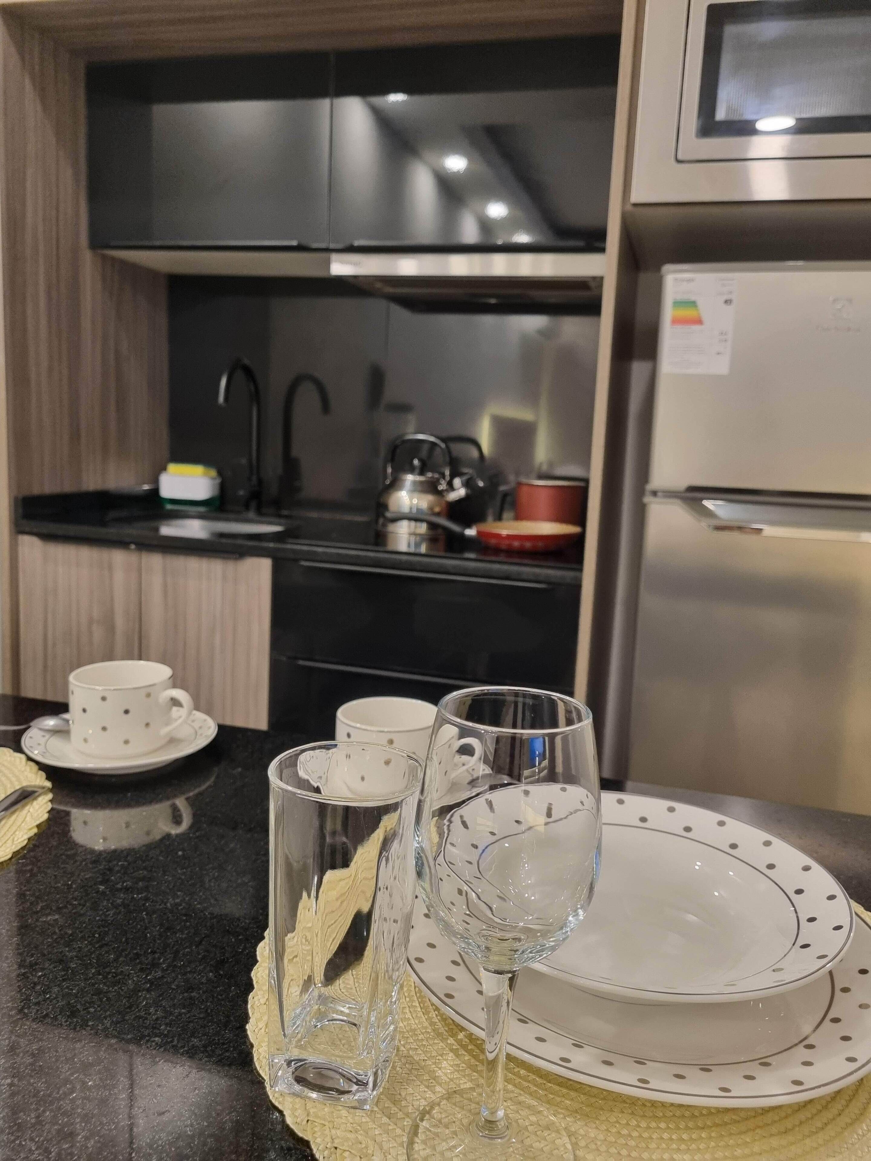 Eine moderne Küche mit schwarzem Arbeitsplatz, Edelstahlgeräten und einem Kühlschrank.