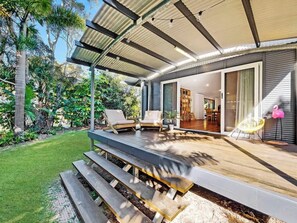 A modern house with a covered patio, outdoor seating, and a view of the interior. - Mudjimba Beach Haven - Stroll to the sea (Mudjimba)