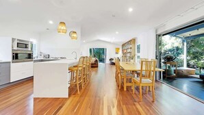 Une cuisine moderne avec un îlot central, des chaises en bois et une table à manger.