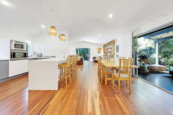 The open plan kitchen and dining area seamlessly flows to the side deck.