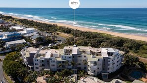 A coastal hotel with multiple buildings, a swimming pool, and a view of the beach and ocean. - Surfside Beachfront 3bed Apt - Direct Beach Access (Buddina)