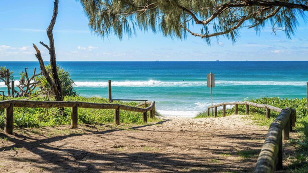 A sandy beach path leading to the ocean with a wooden fence and a signpost. - Surfside Beachfront 3bed Apt - Direct Beach Access (Buddina)