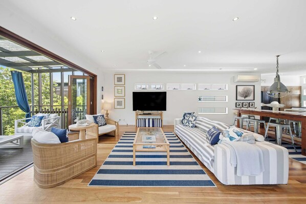 A spacious living room with a large TV, comfortable seating, and a dining area.