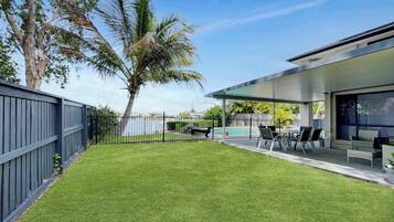 A backyard with a well-maintained lawn, a pool, and outdoor furniture.