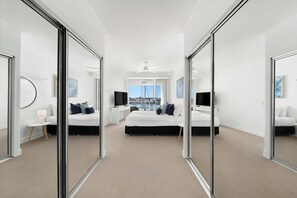 Une chambre d’hôtel moderne dotée d’un grand lit, d’une télévision, d’un bureau et offrant une vue sur la ville.