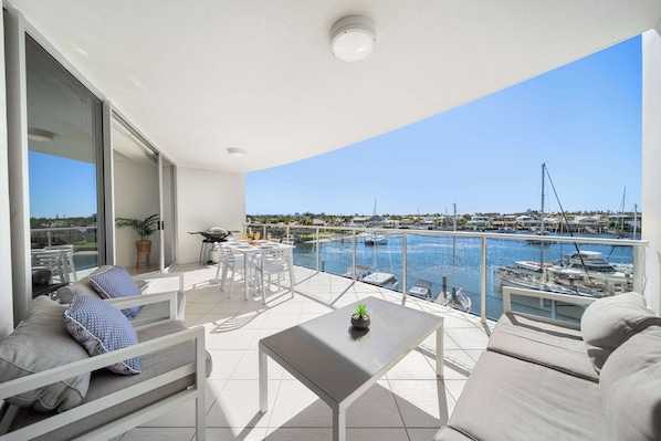 Un balcon avec vue sur le port de plaisance, un coin repas et un espace salon.