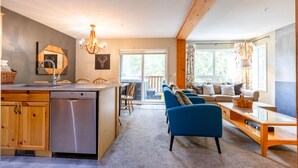 A modern kitchen with a dishwasher, wooden cabinets, and a dining area with a table and chairs.