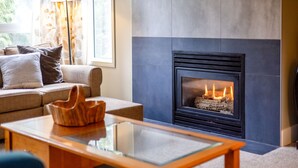 A living room with a fireplace, a sofa, and a coffee table.