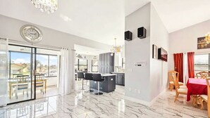 Amplia sala de estar con cocina, comedor y un balcón con vistas.