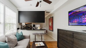 Een moderne woonkamer met een bank, salontafel en een flatscreen televisie aan de muur.