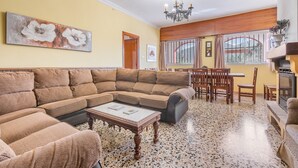 A living room with a sectional sofa, a coffee table, a fireplace, and a dining area. - Country House 'Ana - Cortijo Puerta' with Private Pool, Wi-Fi and Air Conditioning (Órgiva)