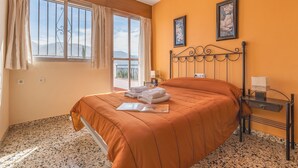 A hotel room with a bed, a window with curtains, a framed picture on the wall, and a small table with a lamp. - Country House 'Ana - Cortijo Puerta' with Private Pool, Wi-Fi and Air Conditioning (Órgiva)